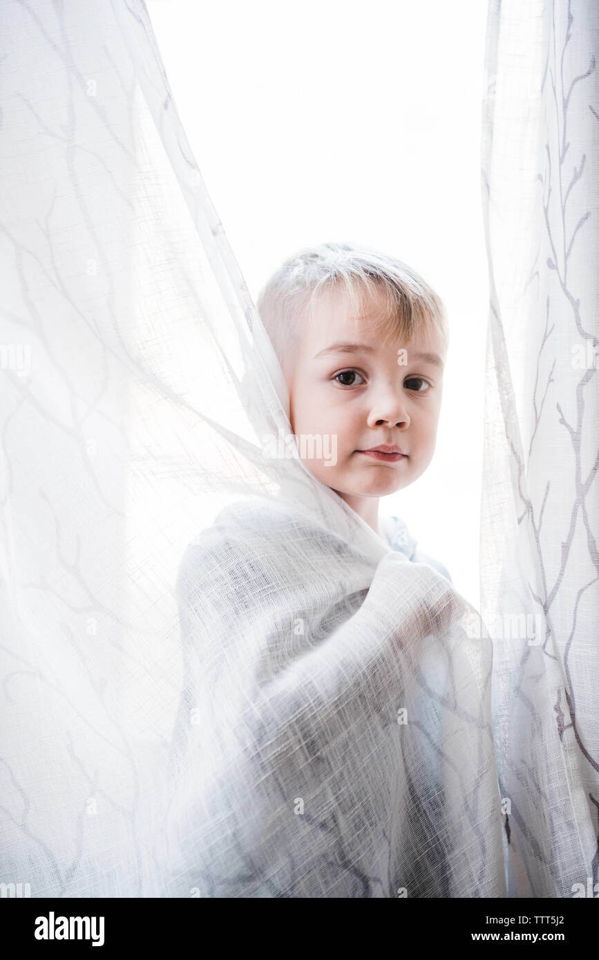 boy playing with curtains. Stock Photo