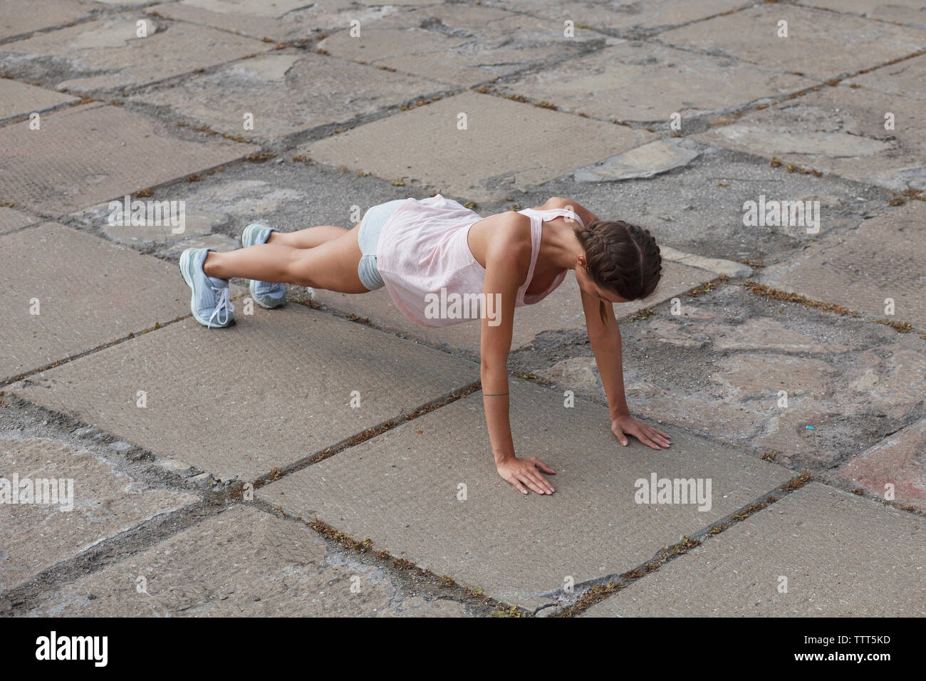High angle view of woman doing push-ups on street in city Stock Photo