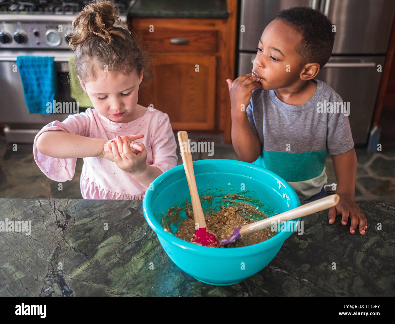 Boy and girl tasting their cookie dough Stock Photo