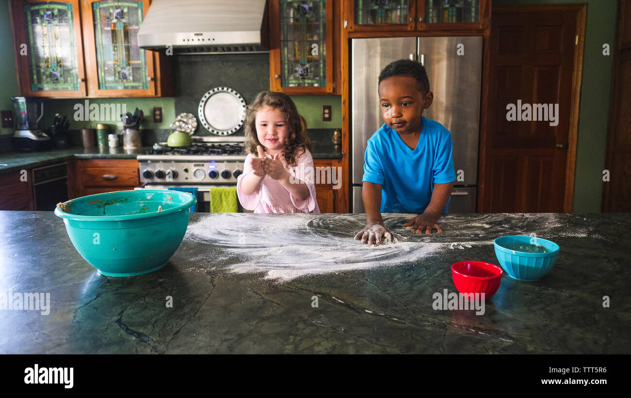 Boy and girl making a mess in the kitchen Stock Photo