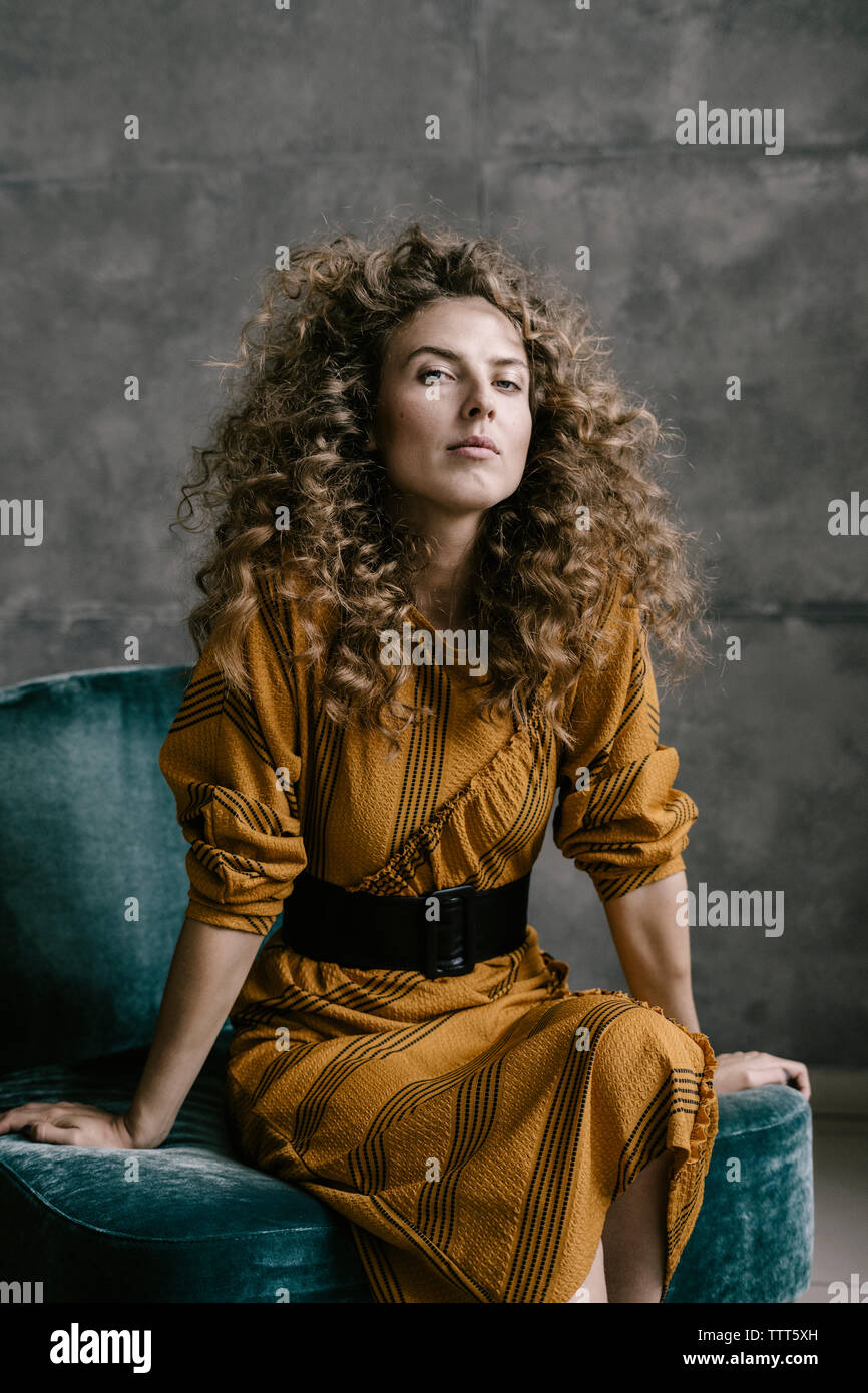Young beautiful curly woman stands on the office in a retro dress Stock Photo
