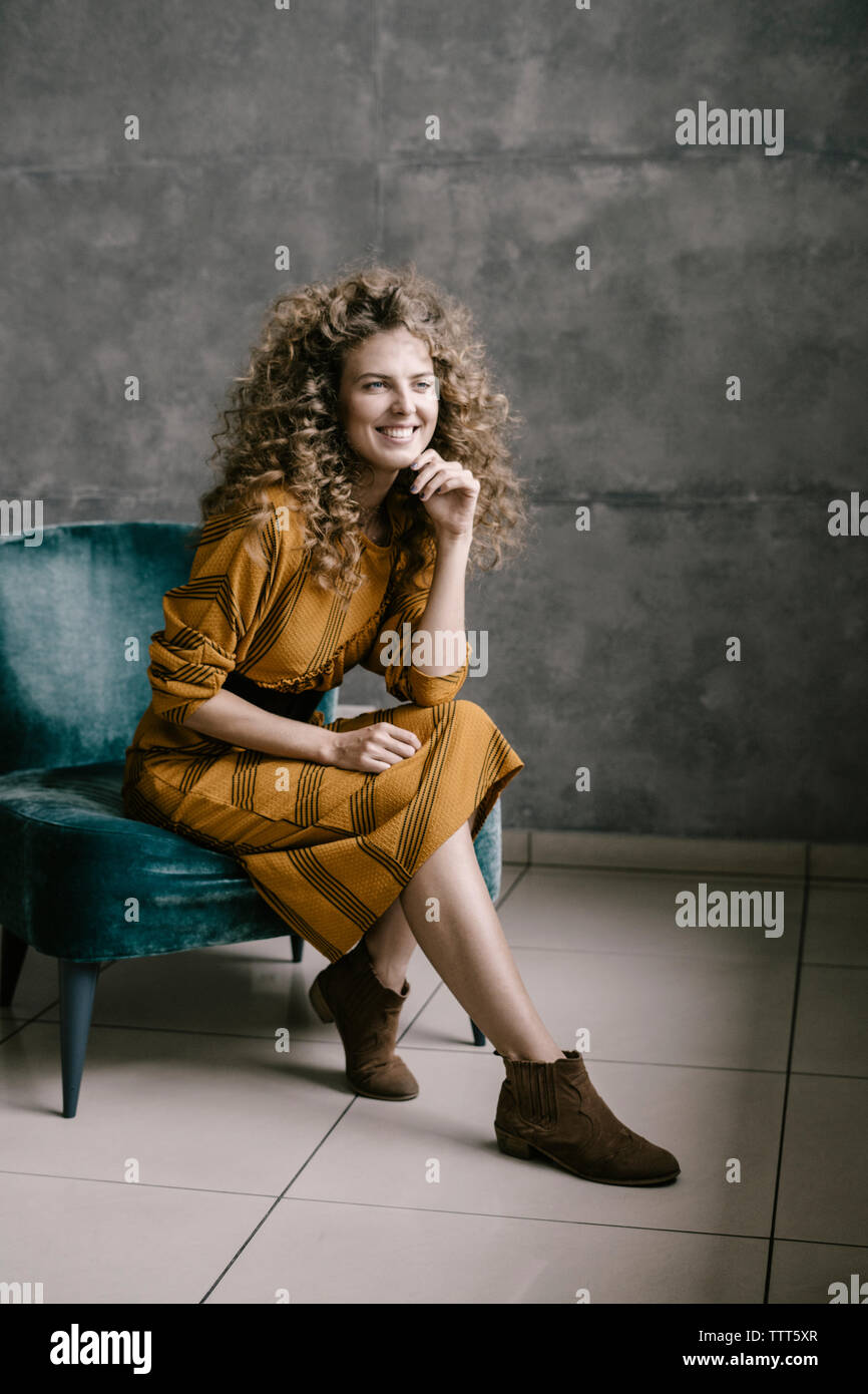 Young beautiful curly woman stands on the office in a retro dress Stock Photo