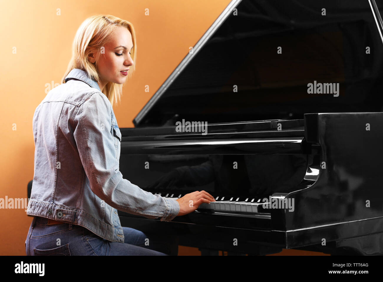 Young woman playing piano in recording studio Stock Photo