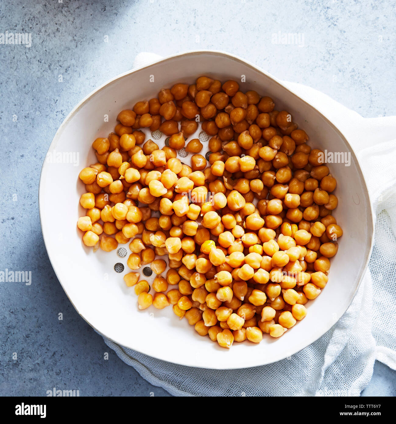 Overhead view of chick-peas in bowl with napkin on table Stock Photo