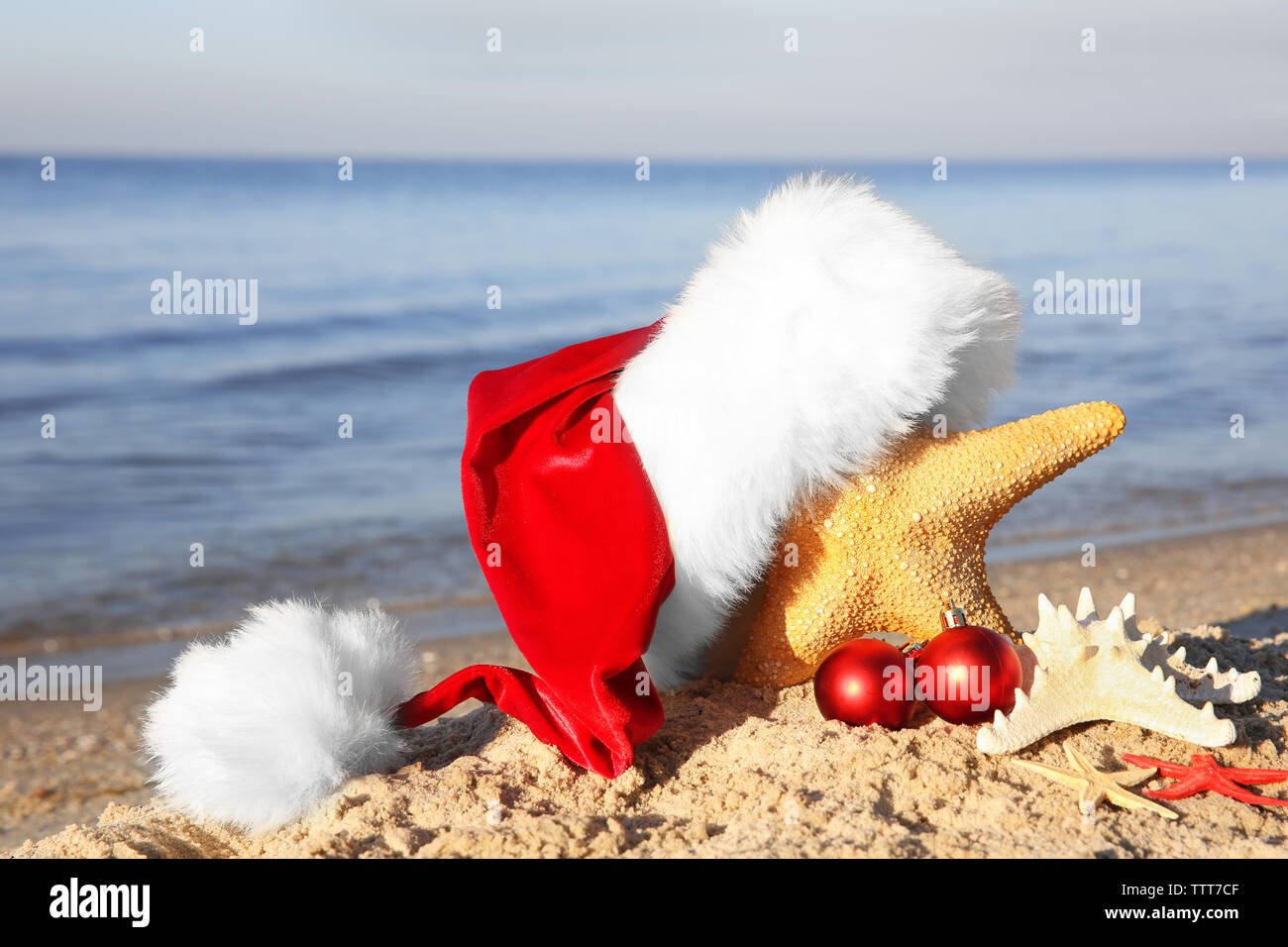 Santa hat with sea stars on beach Stock Photo - Alamy