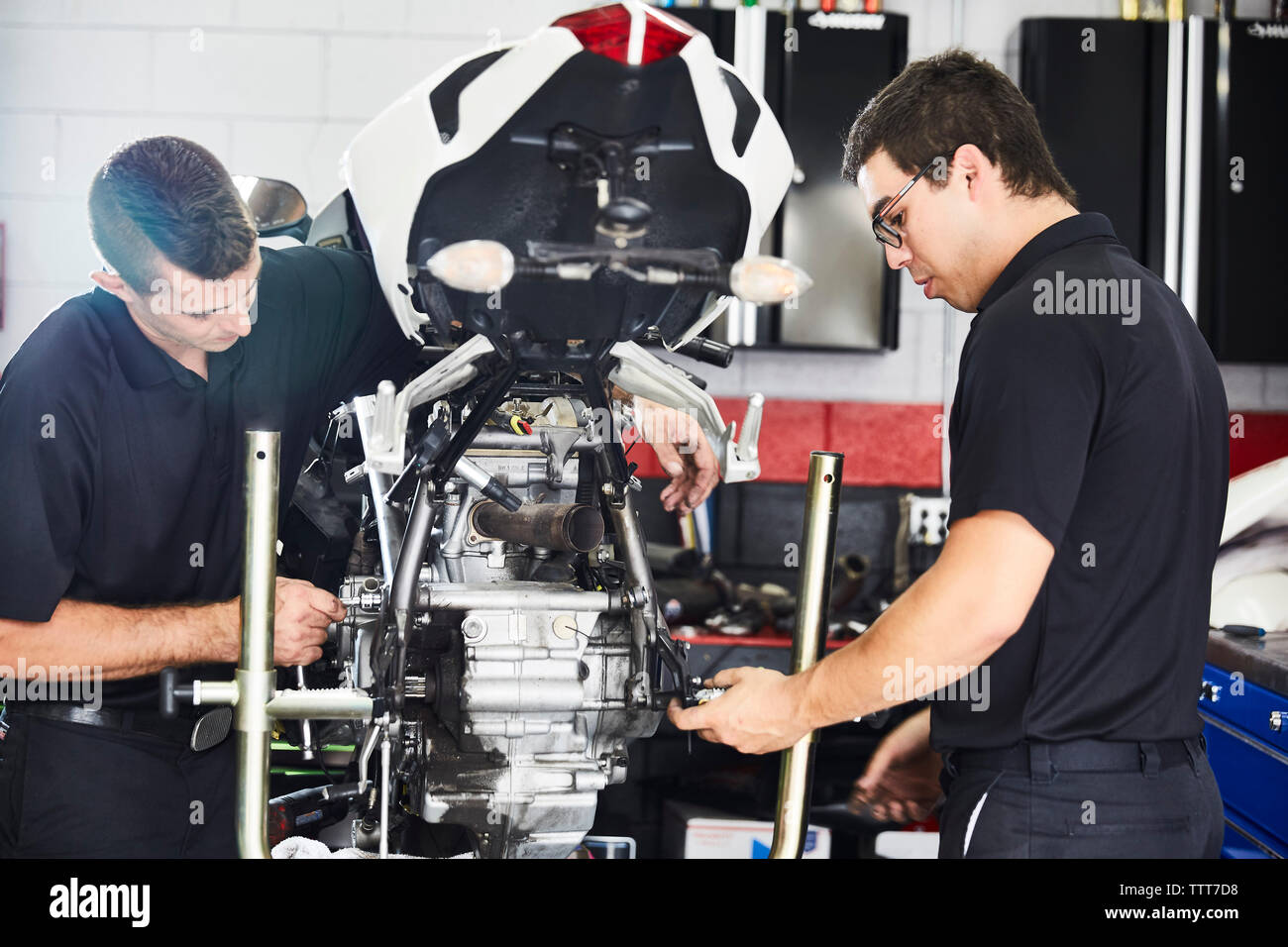 workers examining motorbike in workshop Stock Photo