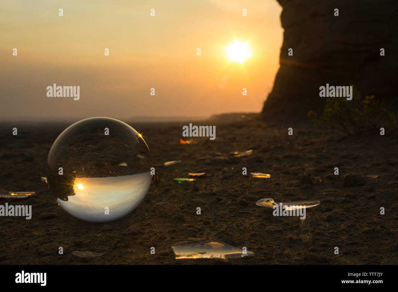 Sun shining over sea shore reflection on crystal ball during sunset Stock Photo