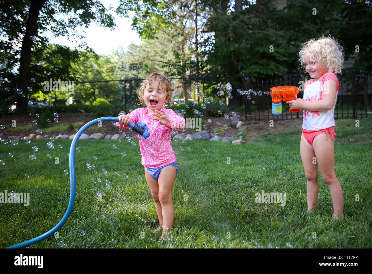 Happy sisters playing in backyard Stock Photo