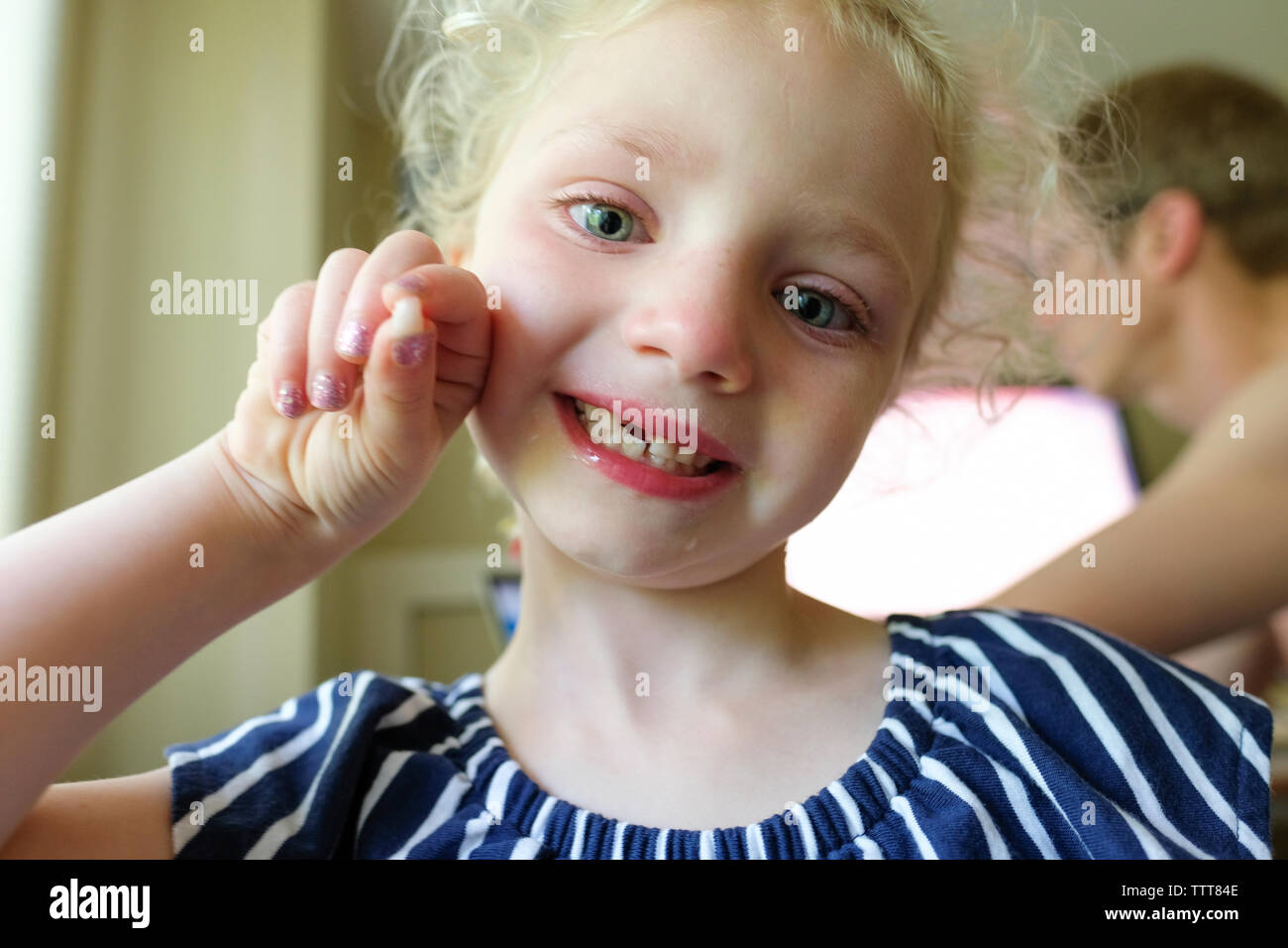 Close-up portrait of smiling girl showing lost primary teeth while standing against father at home Stock Photo