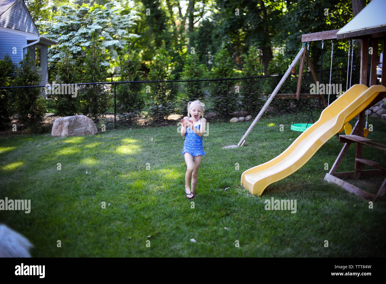 Cute girl screaming while standing on grassy field at playground Stock Photo