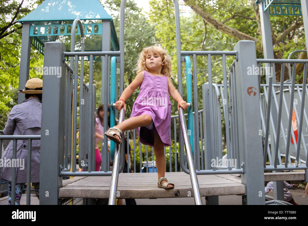 little girl on playground with leg up, ready to move Stock Photo