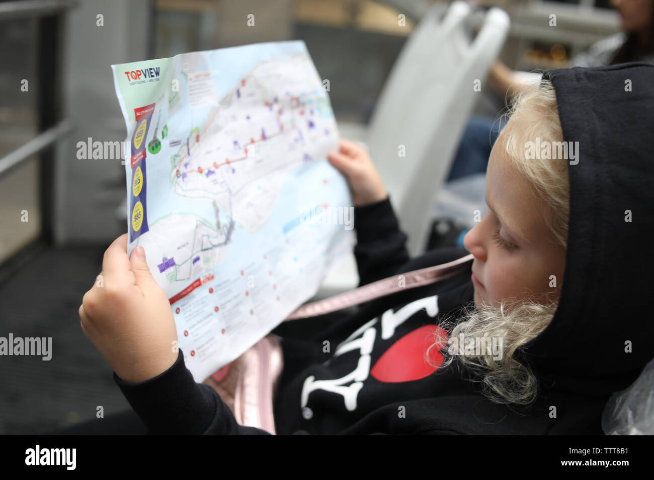 girl looking at map of new york city on sightseeing bus Stock Photo