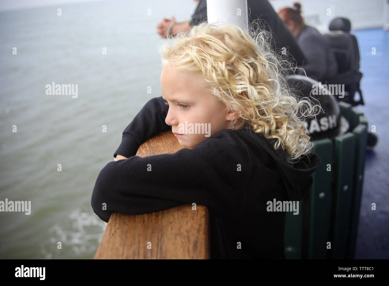 young girl looking out over water on ferry boat standing at railing Stock Photo