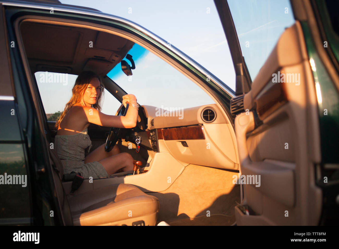 Woman sitting in car seen from open door Stock Photo Alamy