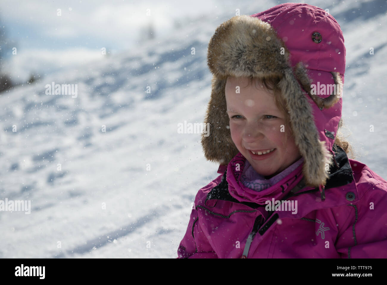 Happy girl smiling in winter wonderland with snow Stock Photo