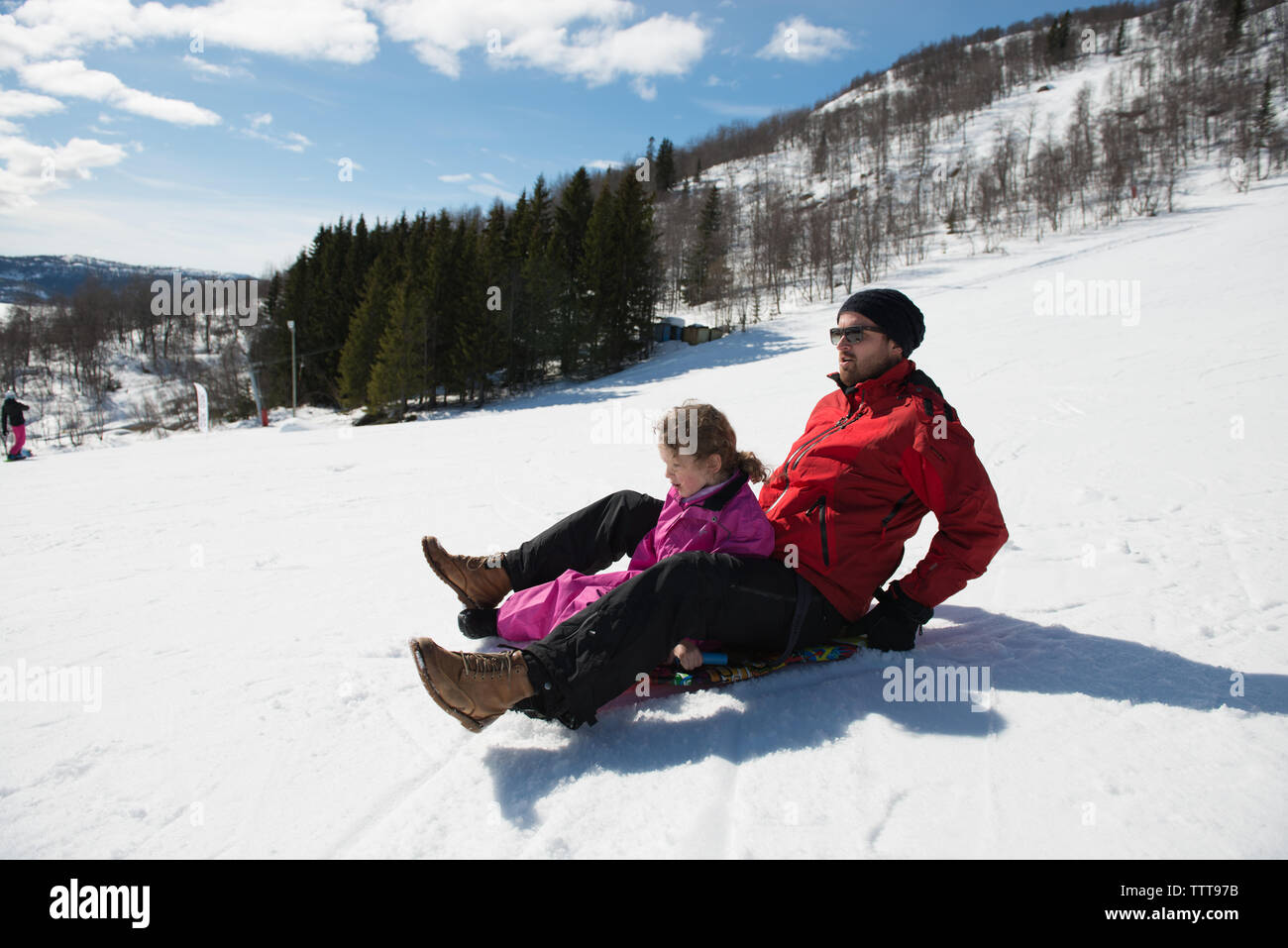 Sledging down a snowy mountain in winter wonderland Stock Photo