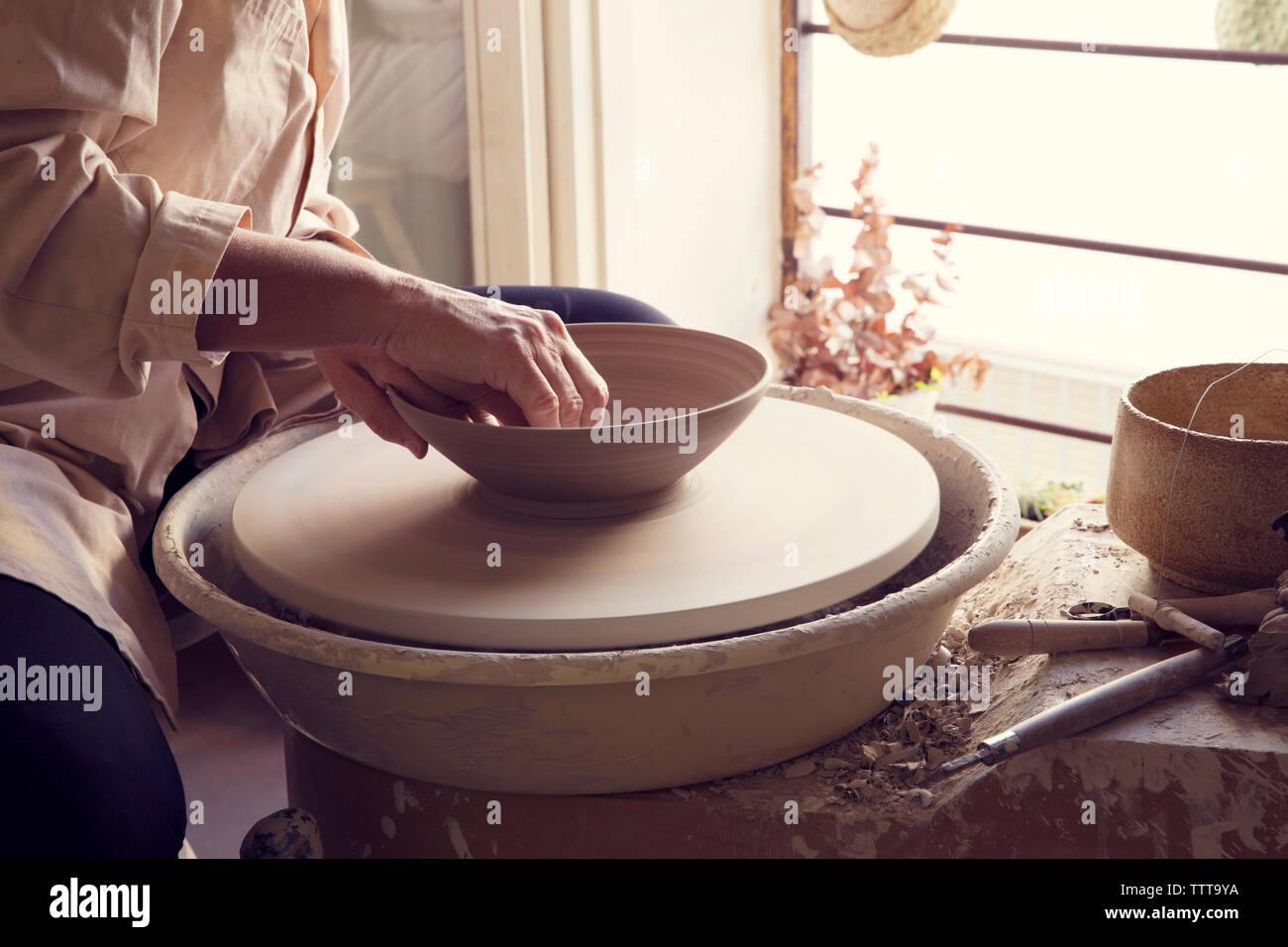 Woman making pot on pottery wheel Stock Photo