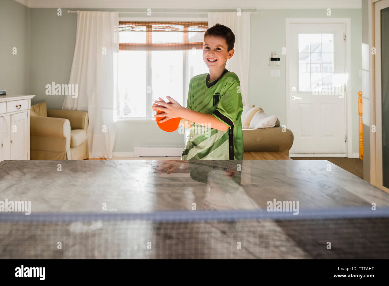 Happy boy playing table tennis at home Stock Photo Alamy