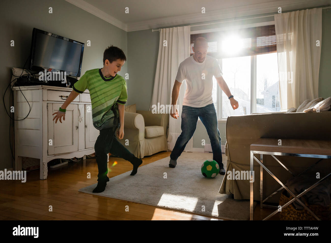 Father with son playing soccer at home Stock Photo