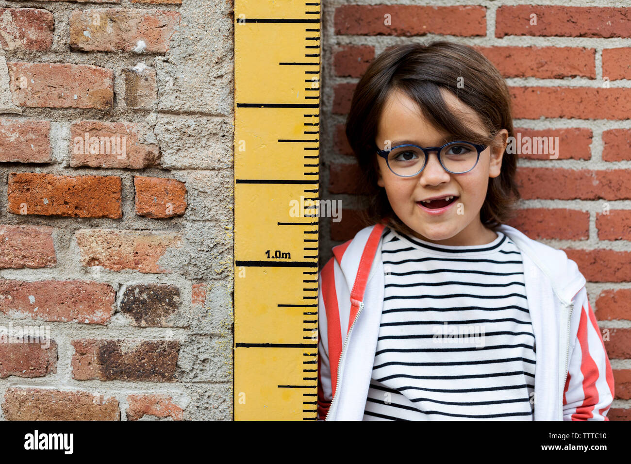 Child In striped top Being Measured On A Keepsake Measuring Stick Stock Photo