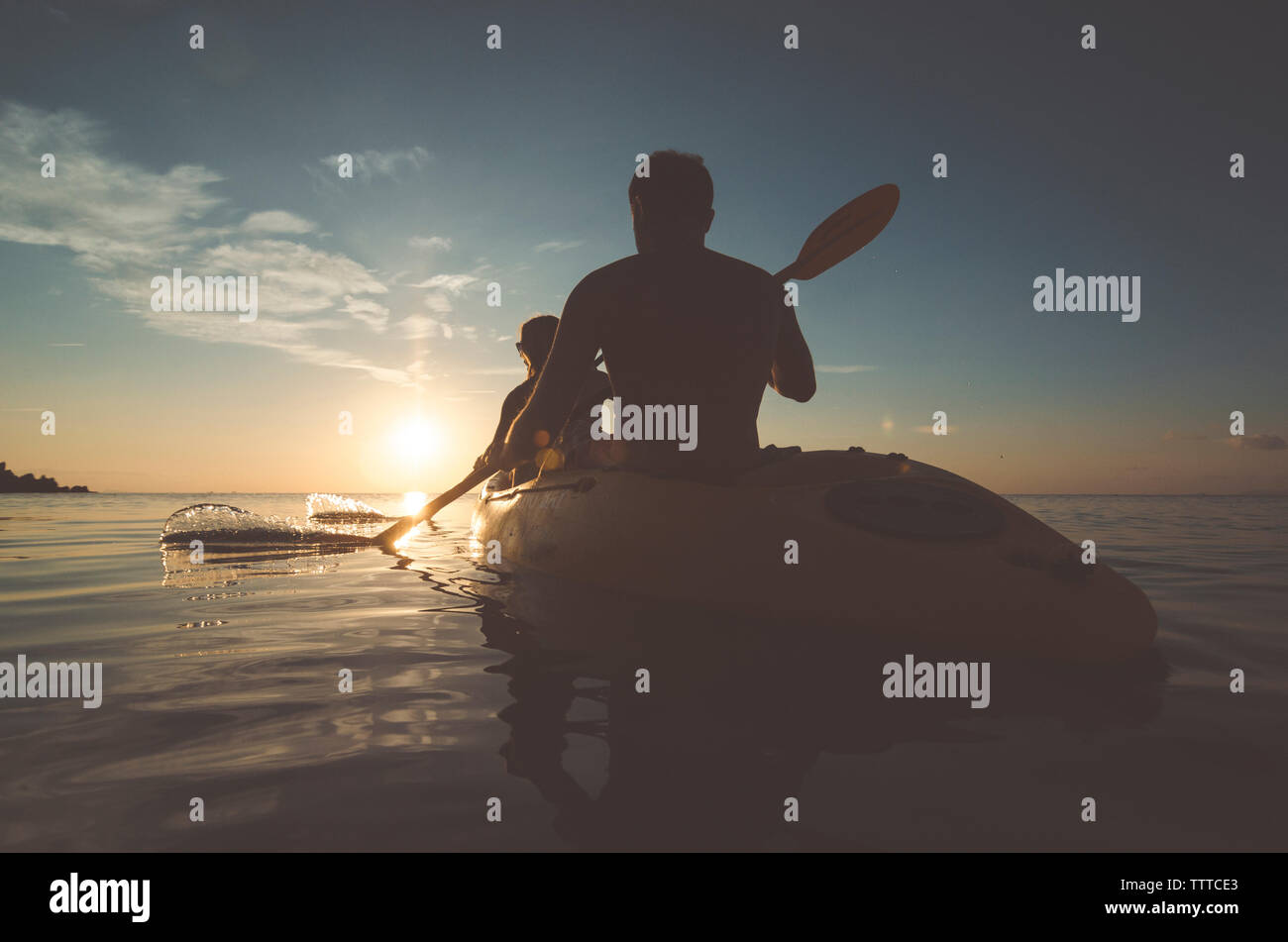 Silhouette friends kayaking on sea during sunset Stock Photo - Alamy
