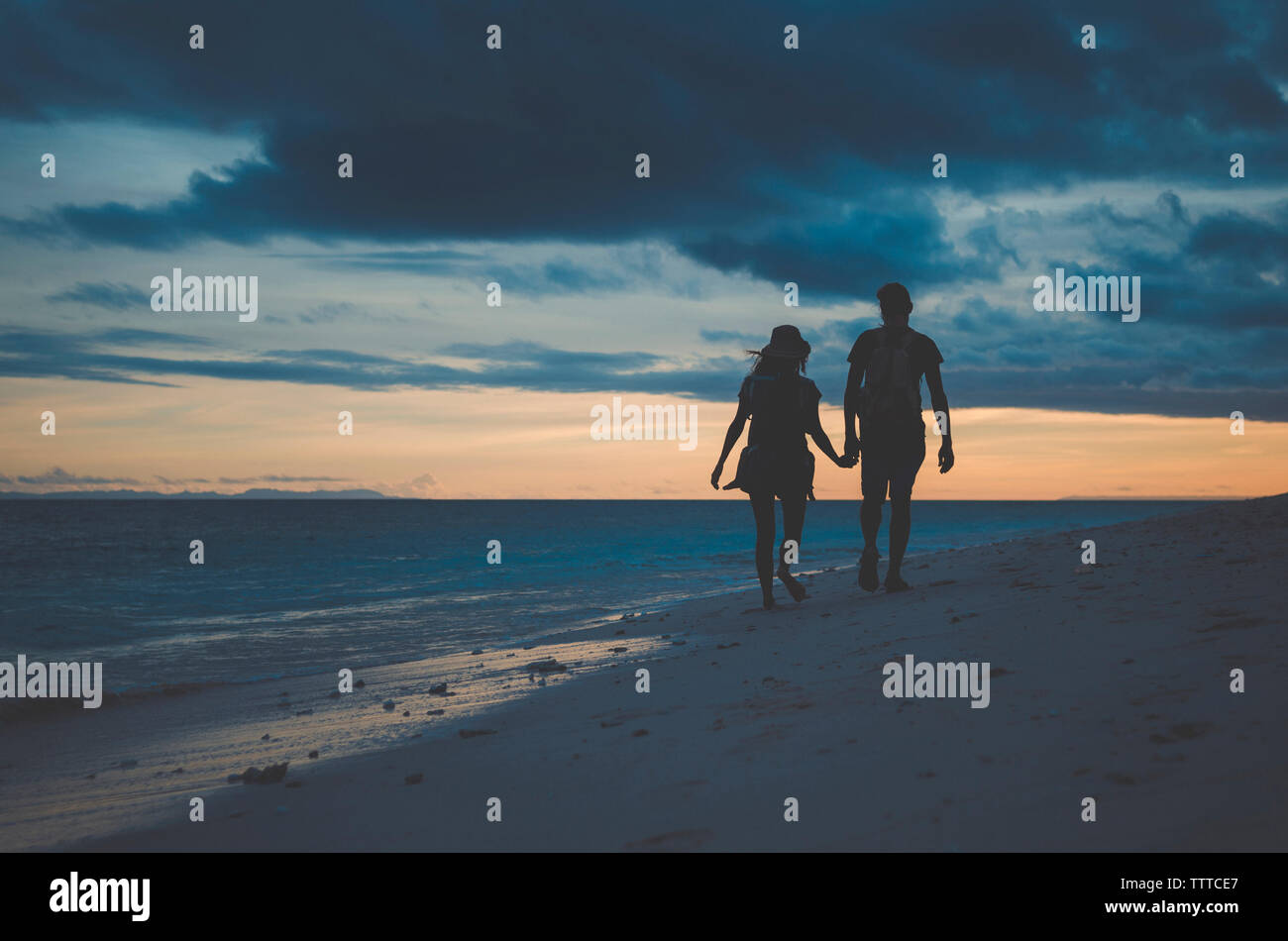 Couple holding hands silhouette beach hi-res stock photography and ...