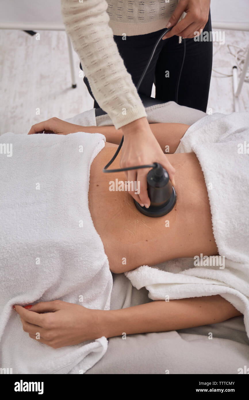 Midsection of female doctor using medical equipment while treating patient at medical clinic Stock Photo