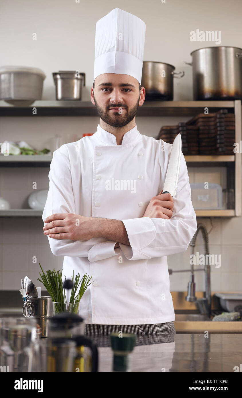 Portrait of confident chef with arms crossed standing at commercial kitchen Stock Photo