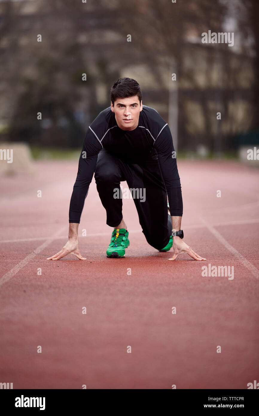 Portrait of male athlete at starting line Stock Photo - Alamy