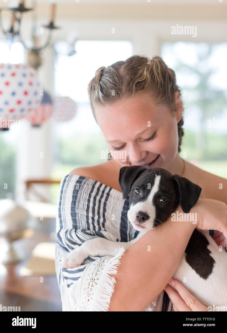 child holing a black and white puppy with floppy ears Stock Photo