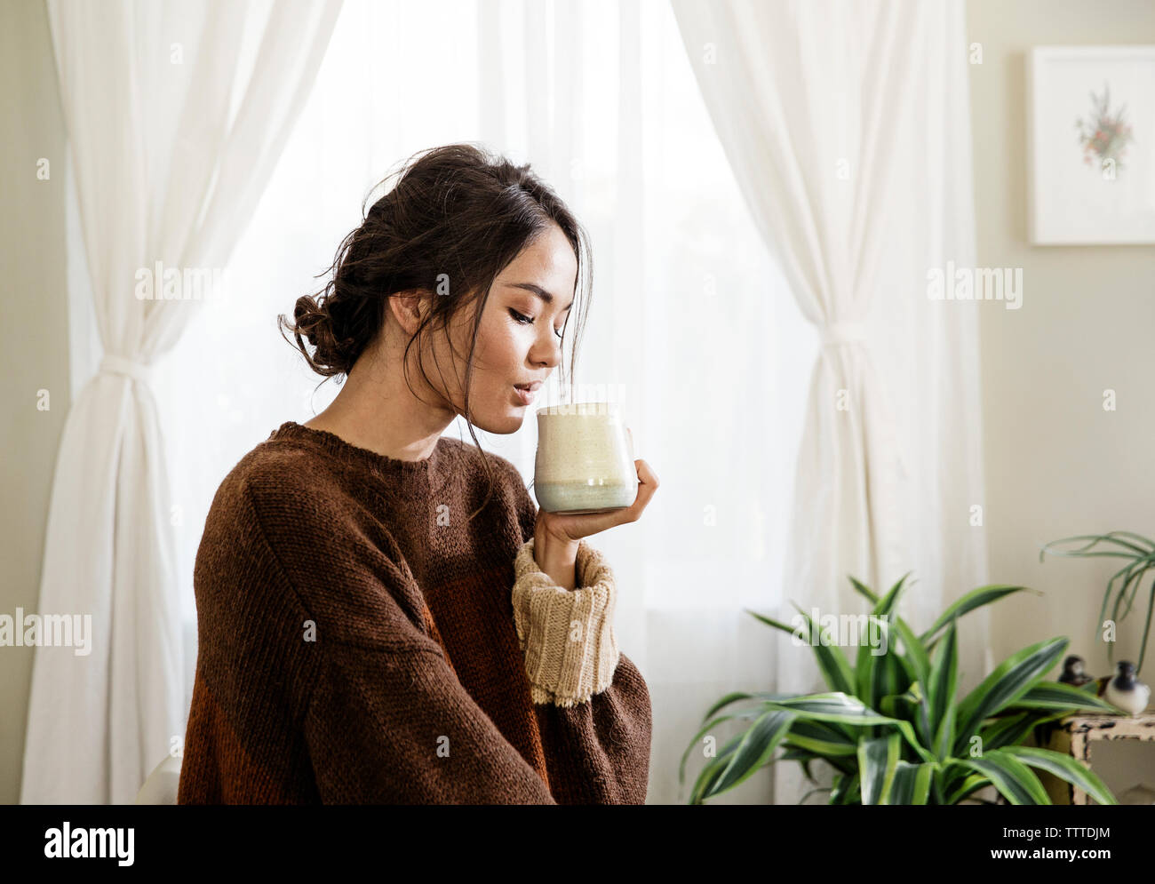 Young woman drinking coffee at home Stock Photo