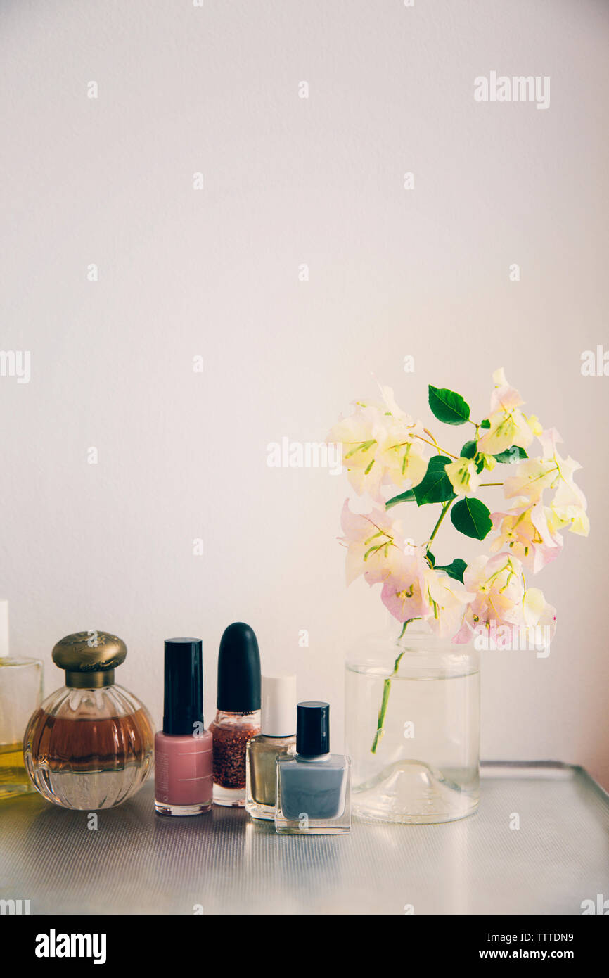 Beauty products arranged by flower vase on table Stock Photo