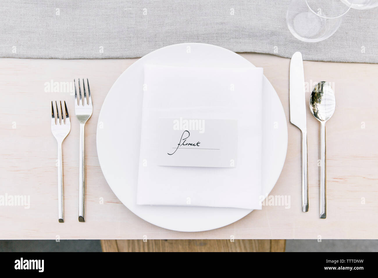 Overhead view of silverware by plate with text on dinning table Stock Photo