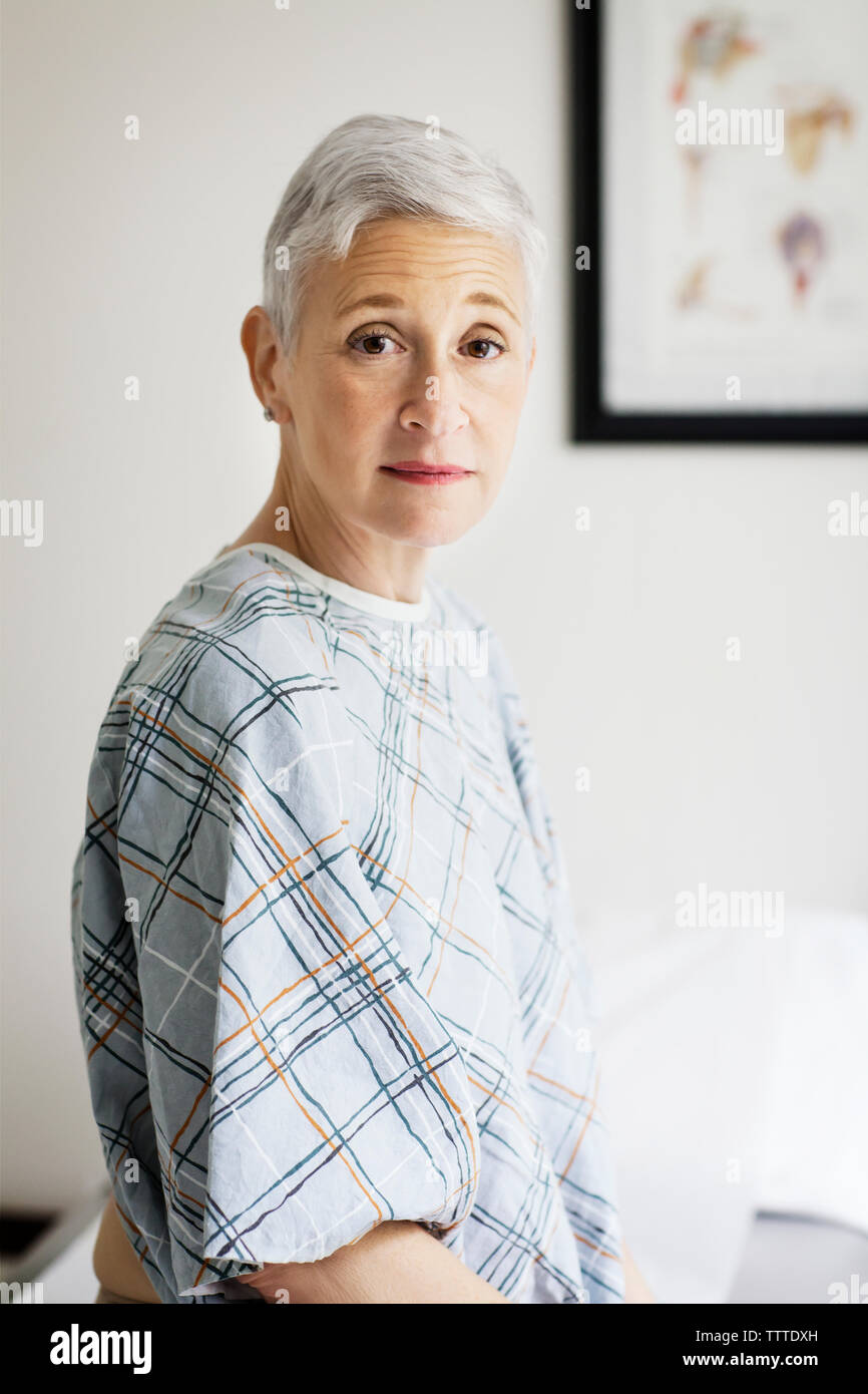 Portrait of female patient wearing hospital gown in clinic Stock Photo