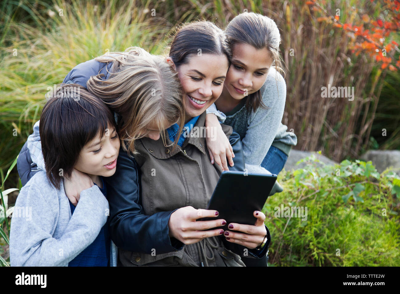Teacher showing tablet computer to children during field trip Stock Photo