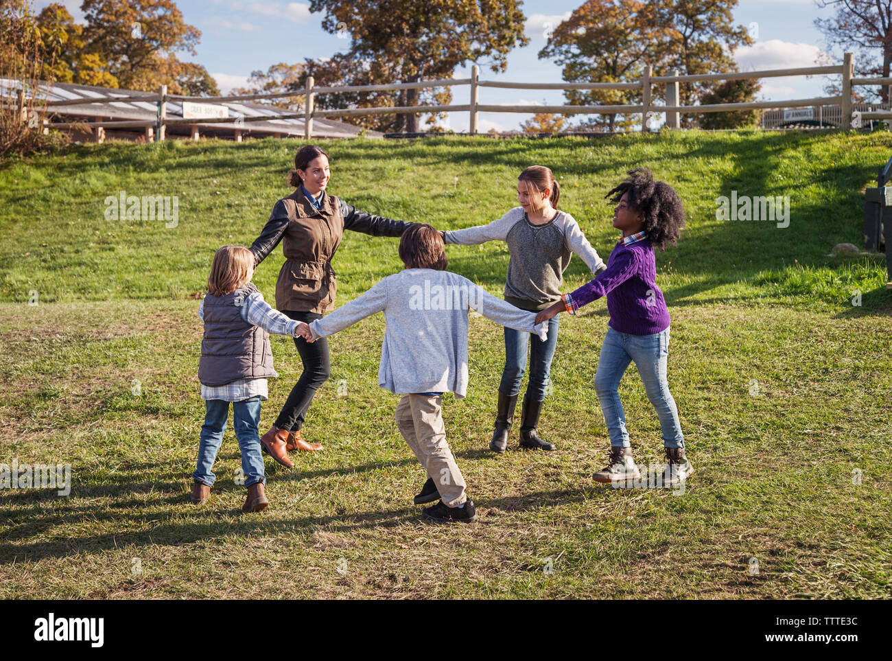 Teacher playing with students on field during field trip Stock Photo