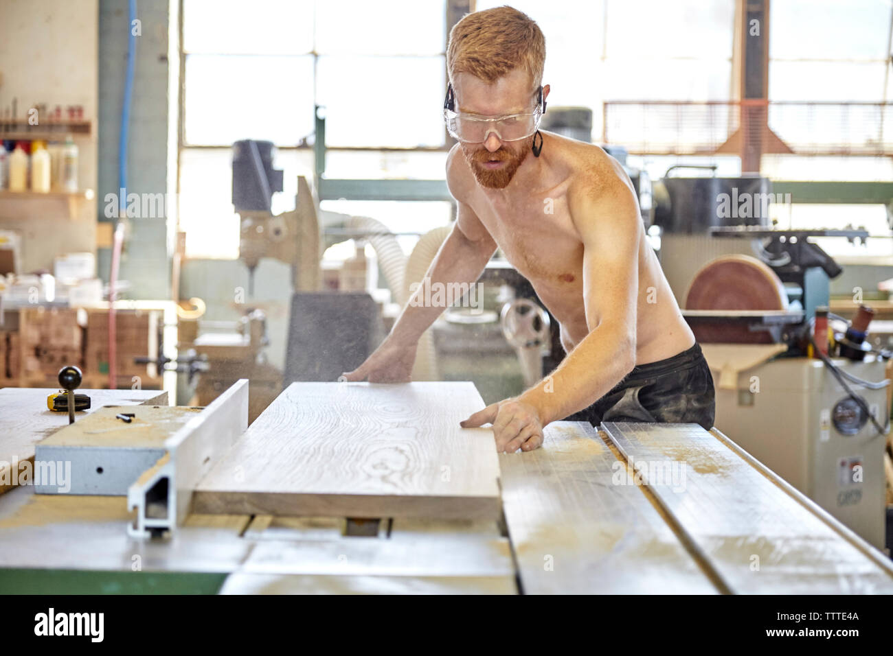 Shirtless carpenter working in workshop Stock Photo - Alamy