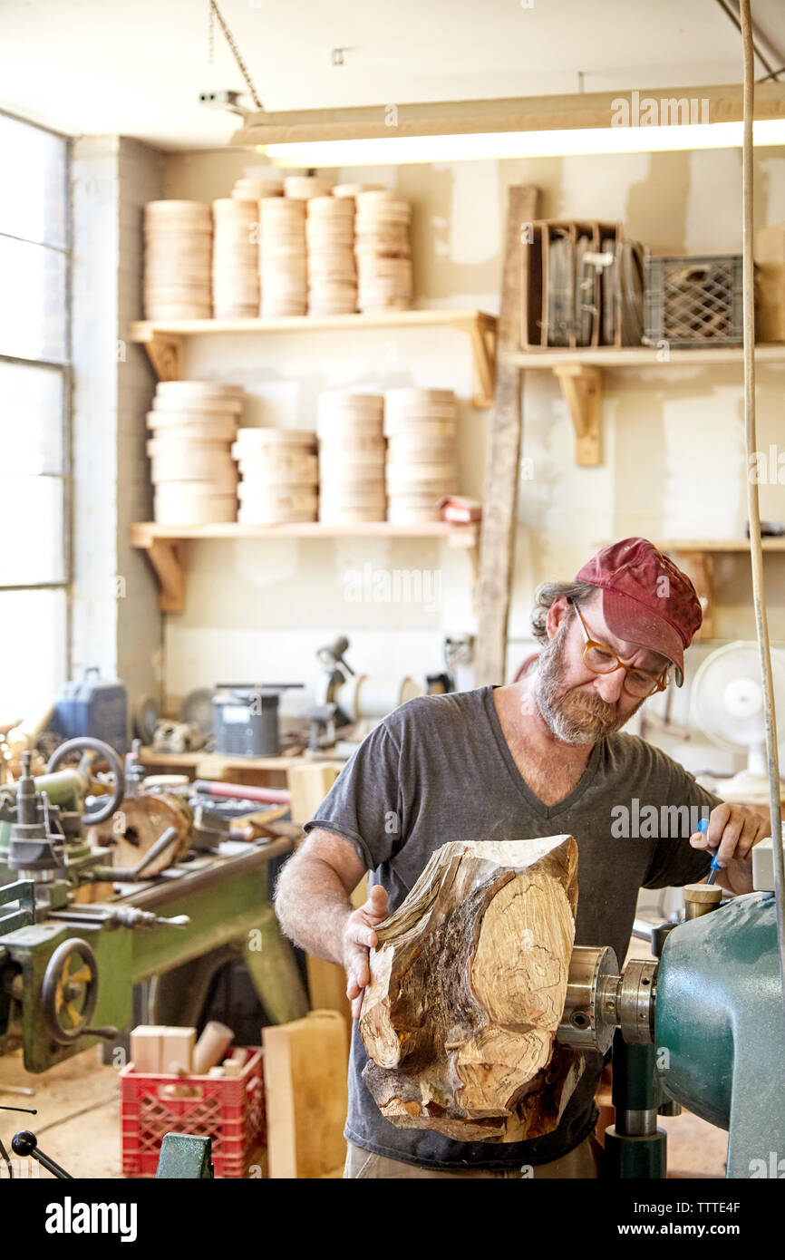 Carpenter using machinery in workshop Stock Photo