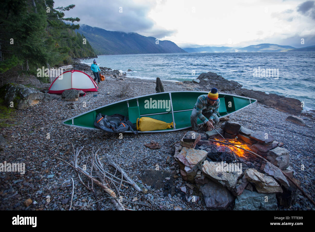 Couple canoe camping with campfire on Lake Pend Oreille, Idaho. Stock Photo