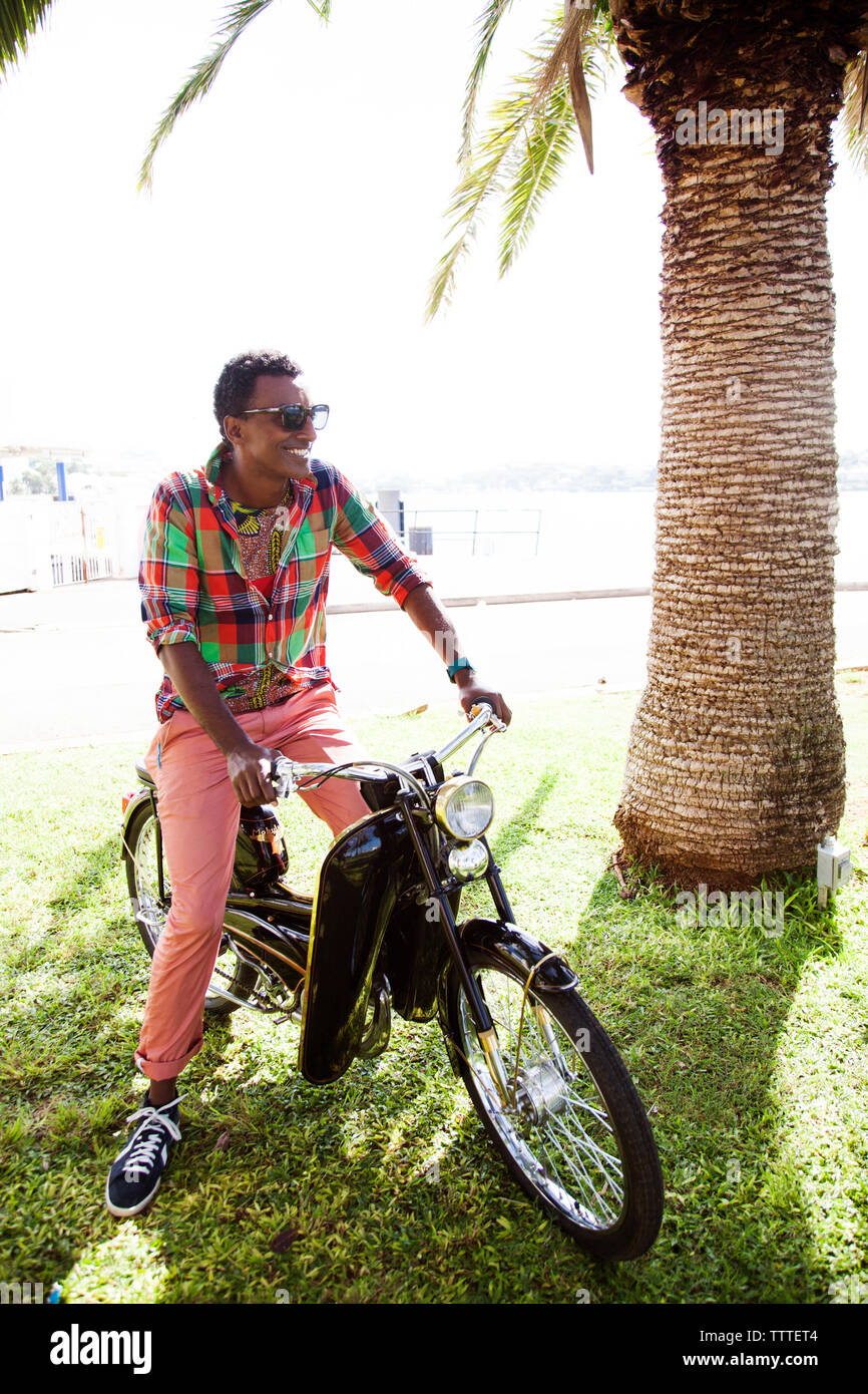 BERMUDA, Hamilton. Chef Marcus Samuelsson on a vintage scooter in Barr's Bay Park located in downtown Hamilton. The Hamilton Harbour is in the backgro Stock Photo