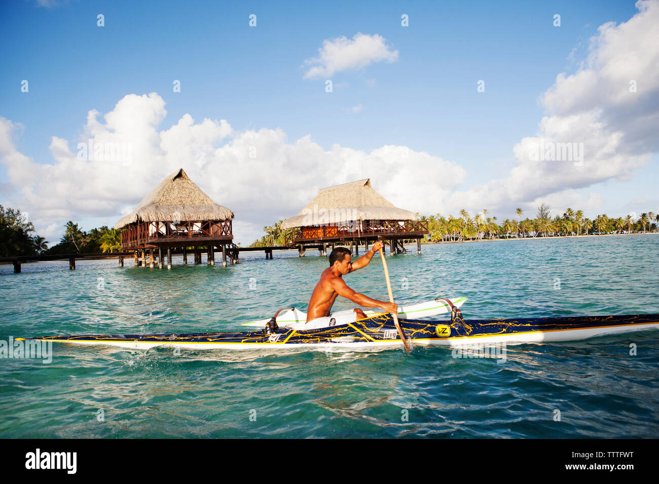 FRENCH POLYNESIA, Tahaa Island. Roe, riding his outrigger canoe by the