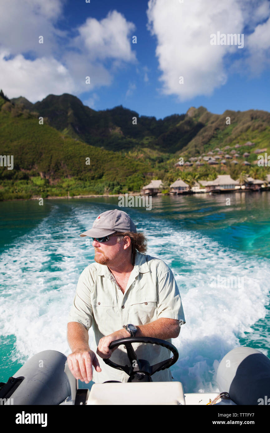 FRENCH POLYNESIA, Moorea. A boat ride with the Intercontinental Moorea Resort and Spa in the background. Stock Photo