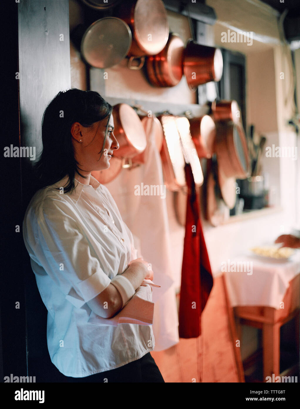 ITALY, Soave, waitress standing with arms crossed in kitchen of Ristorante Groto De Corgnan. Stock Photo
