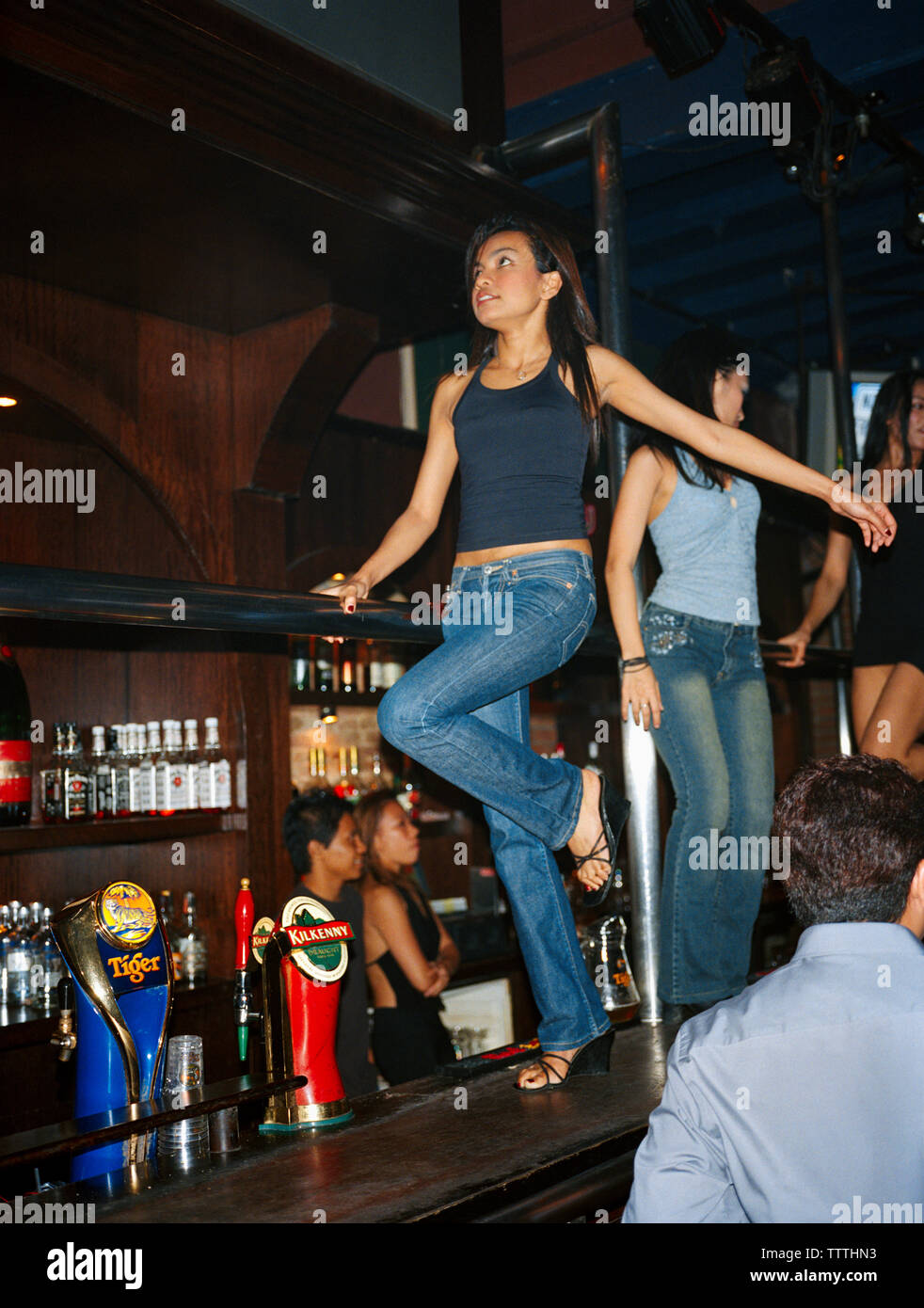 SINGAPORE, female bartenders dancing in CU Nightclub bar. Stock Photo