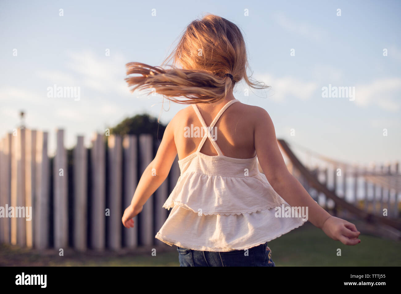 Little girl imagining she's a dancer, spinning and twirling in the sun Stock Photo