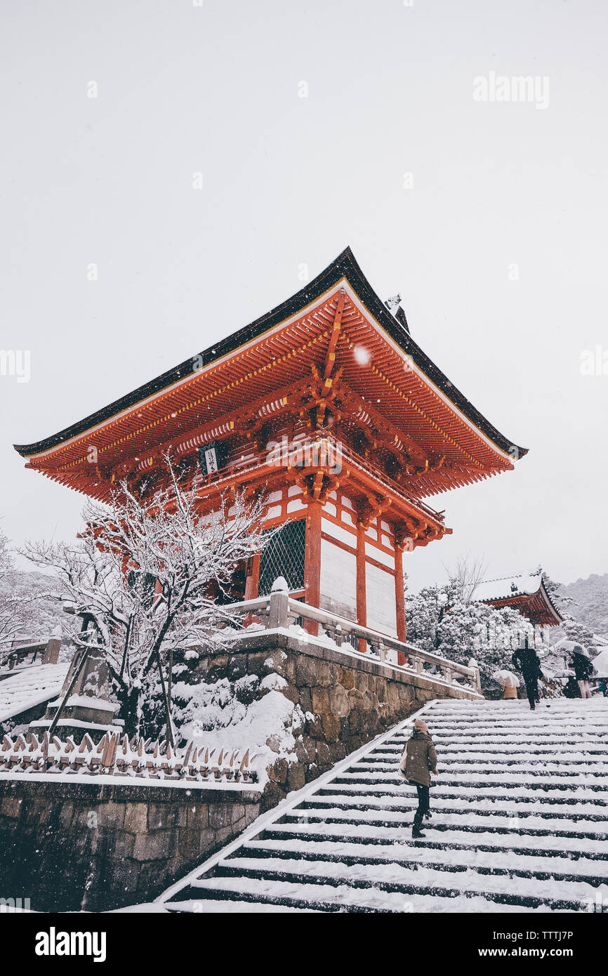 Low angle view of Kiyomizu-dera Temple against clear sky during snowfall Stock Photo