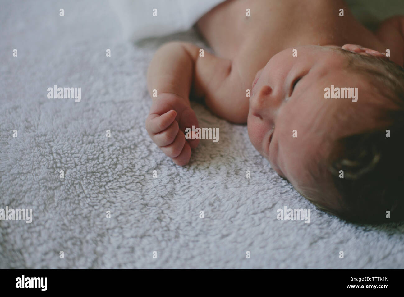 Closeup of cute baby lying on blanket in bed Stock Photo Alamy