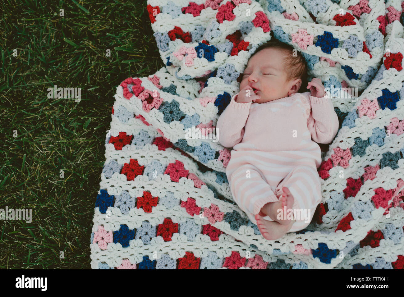 Overhead view of baby girl sleeping on blanket in yard Stock Photo Alamy