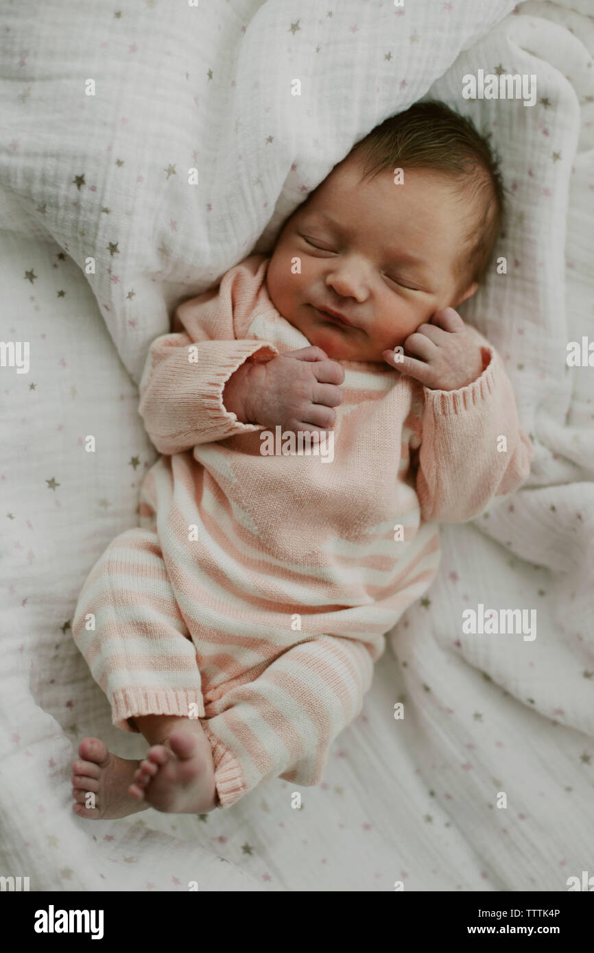 Overhead view of baby girl sleeping with eyes closed on blanket Stock
