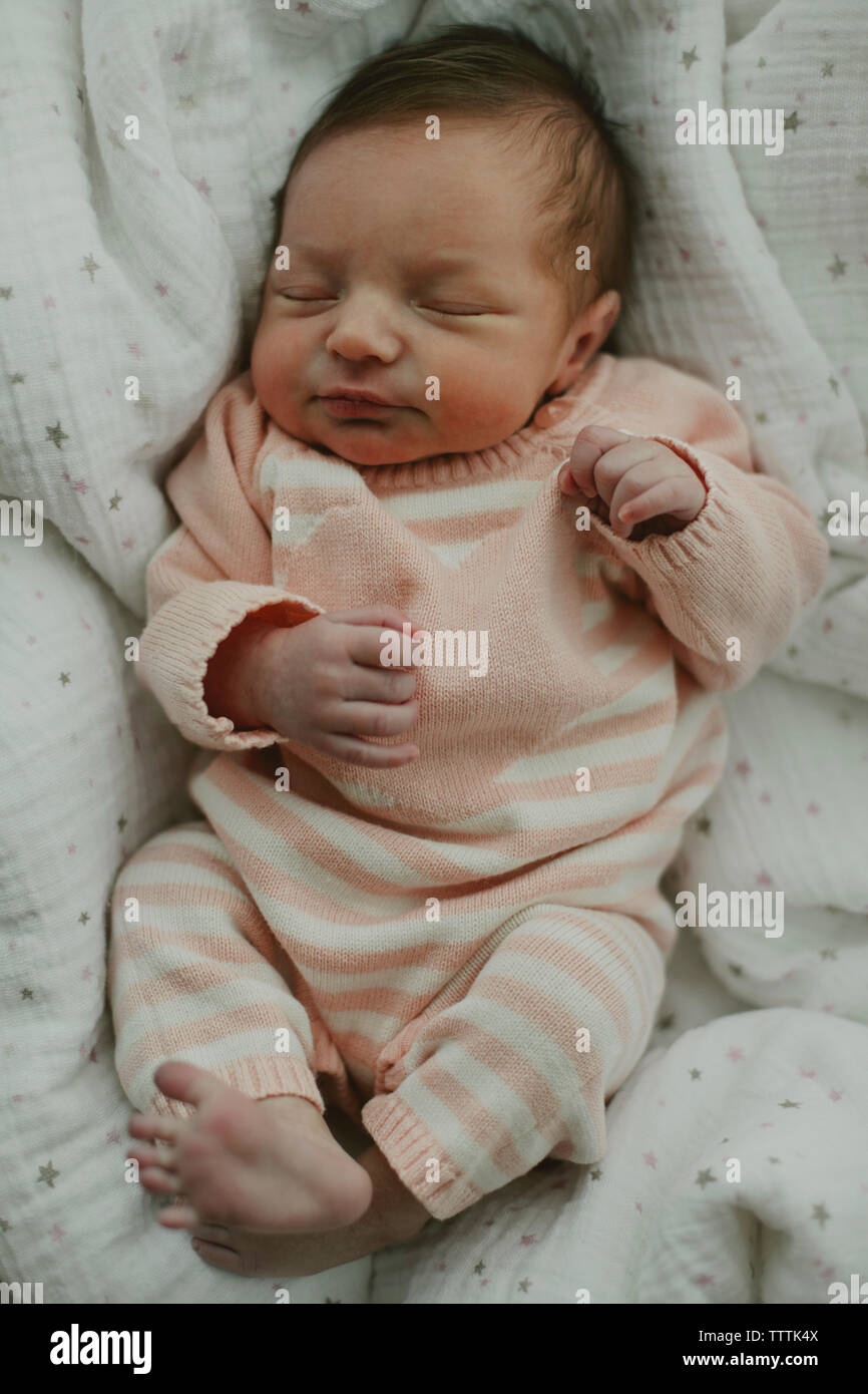 Overhead view of cute baby girl sleeping with eyes closed in crib Stock